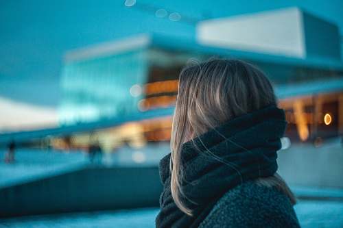 person woman standing near building under dark cloudy sky human