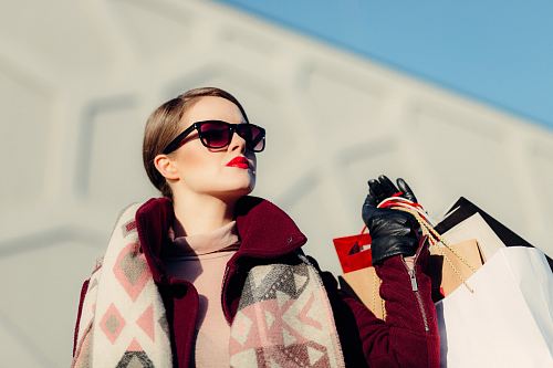shallow focus photography of woman holding shopping bags during day