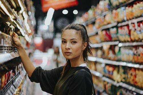 woman selecting packed food on gondola