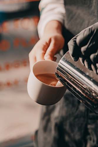 dessert person pouring cream on white ceramic mug beverage