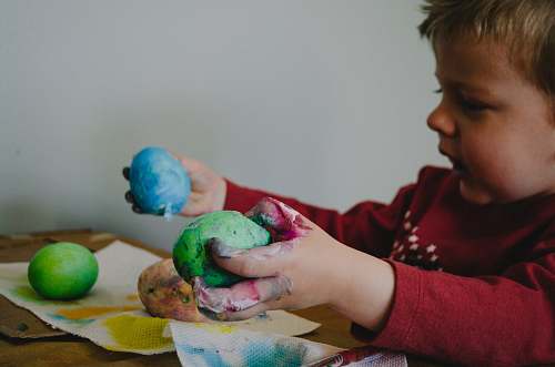 people boy holding blue and green painted egg shells person