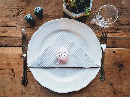 flora white ceramic plate beside gray fork jar