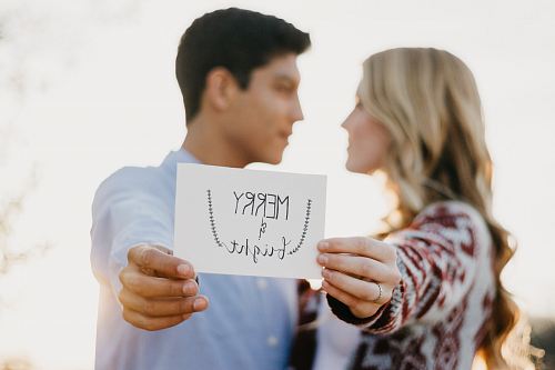 couples holding Merry & Bright card