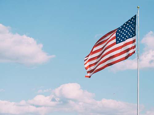 emblem flag of U.S.A. under white clouds during daytime america