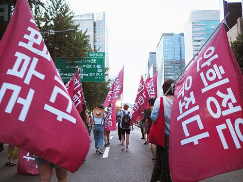 text people on road with banners during daytime banner