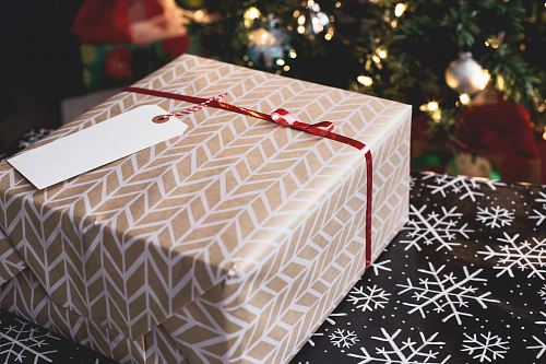 gold and white gift box on black and white fair-isle print surface