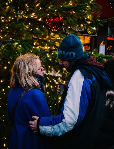 man and woman looking face to face near christmas tree