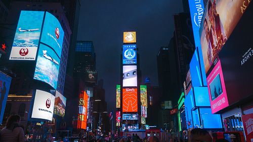 people walks between building during nighttime