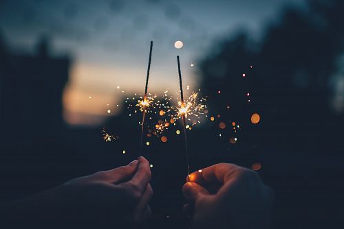 person holding fire cracker shallow focus photography