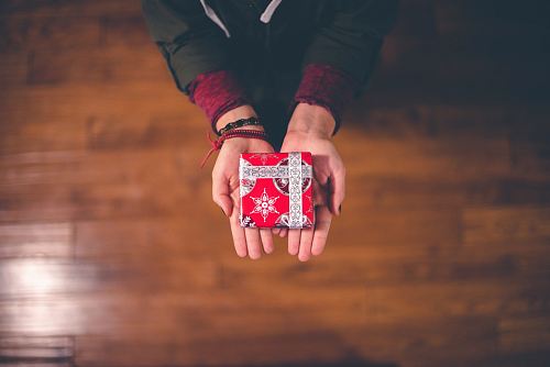 person holding red and white box