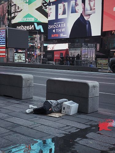 person laying on concrete floor beside asphalt road