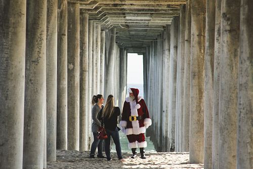 Santa Claus talking to woman near concrete post