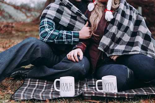 two person cuddling on gray plaid mat