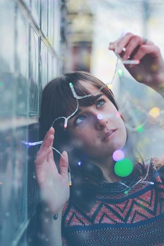 woman holding string lights