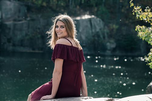 woman sitting on rack near river