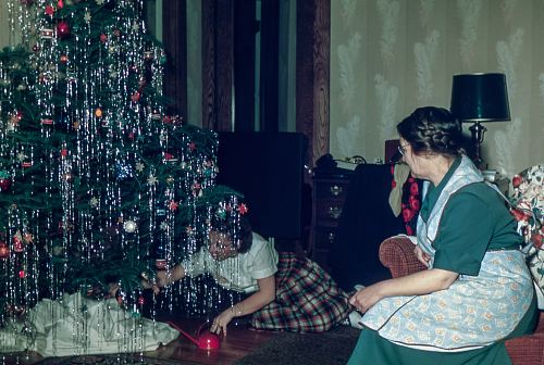 woman sitting under Christmas tree