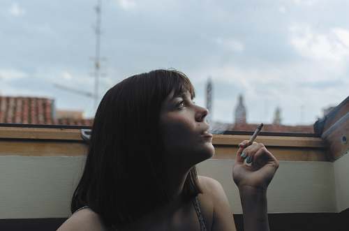 person woman holding stick cigarette during day time human