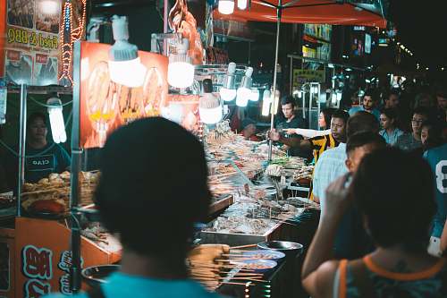 person group of people standing beside stall market