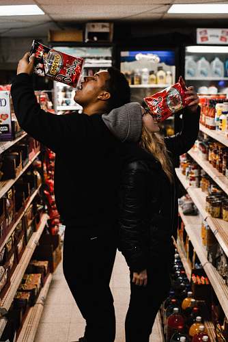 person man and woman eating chips in shallow photo shelf