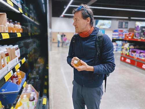 shop man standing beside display shelf grocery store