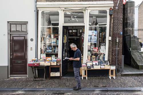 person man standing in front of a bookshop indoors