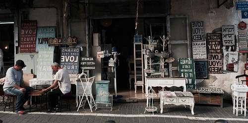 person two men sitting in front of table beside assorted wall decors store furniture