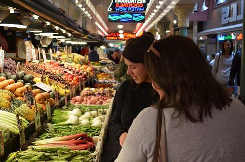 person two woman standing beside vegetable display grocery store