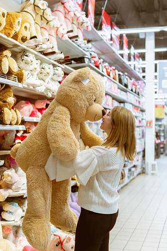 shop woman carrying life size bear plush toy teddy bear