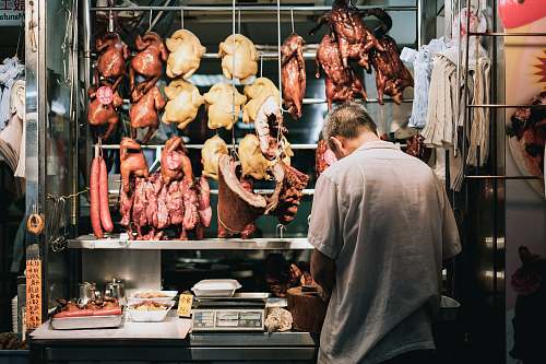 human man standing on store butcher shop