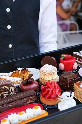 human person standing beside tray of food bakery