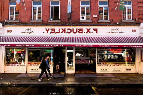 dublin man and woman walking in front of F.X. Buckley store ireland