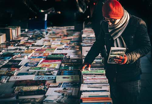 person man picking up book ob book sale books