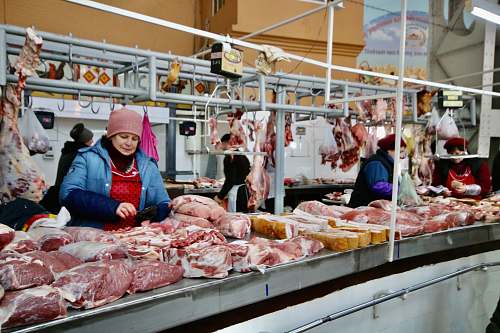 human photography of women standing in front of meats butcher shop