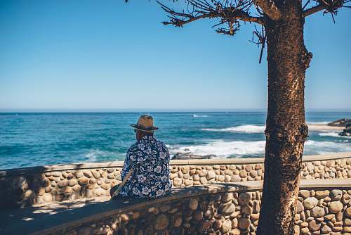 ocean man sitting facing sea waves