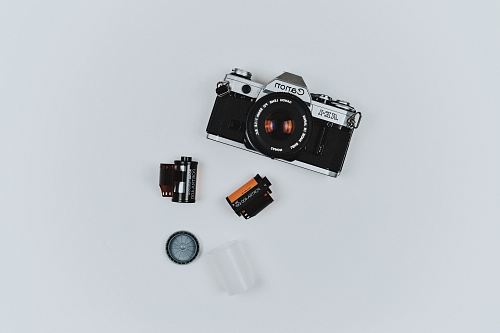 black Canon film camera with two films in flat lay photography