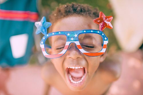 boy wearing American flag print eyeglasses sticking his mouth open