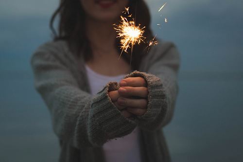 focus photo of a woman holding sparklers