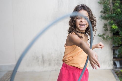 girl playing hula hoop on his arm