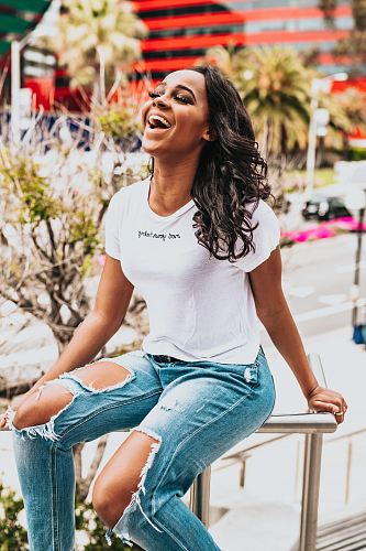 girl sitting on metal hand rail while laughing