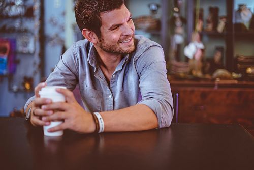 man holding cup on table