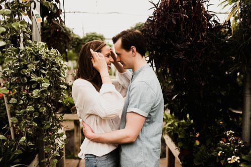man holding waist of woman surrounded plants