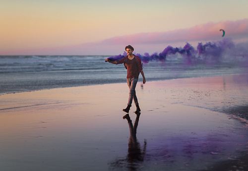 man in red shirt walking on the shore