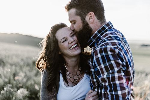 man kissing woman in grass area