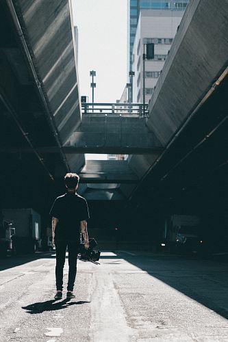 man walking under the bridge
