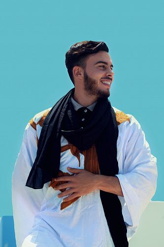 man wearing black shawl touching stomach