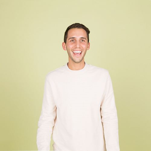man wearing white crew-neck long-sleeved shirt standing inside well lighted room