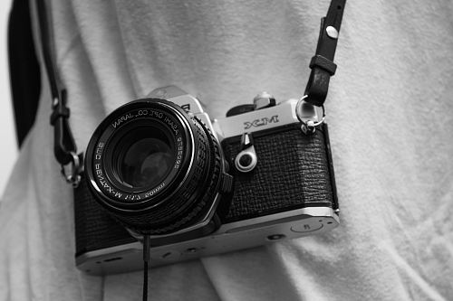 person holding black and gray film camera with sling