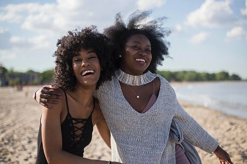 photo of woman beside another woman at seashore