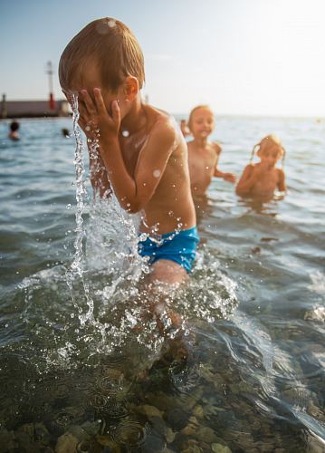 toddler pouring a water on his face