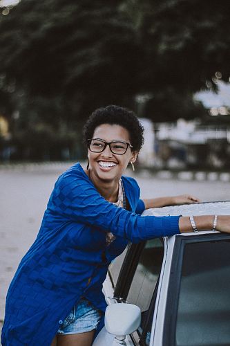 woman beside white vehicle during daytime